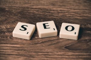 Scrabble tiles spelling SEO financial on a wooden surface. Ideal for digital marketing themes.